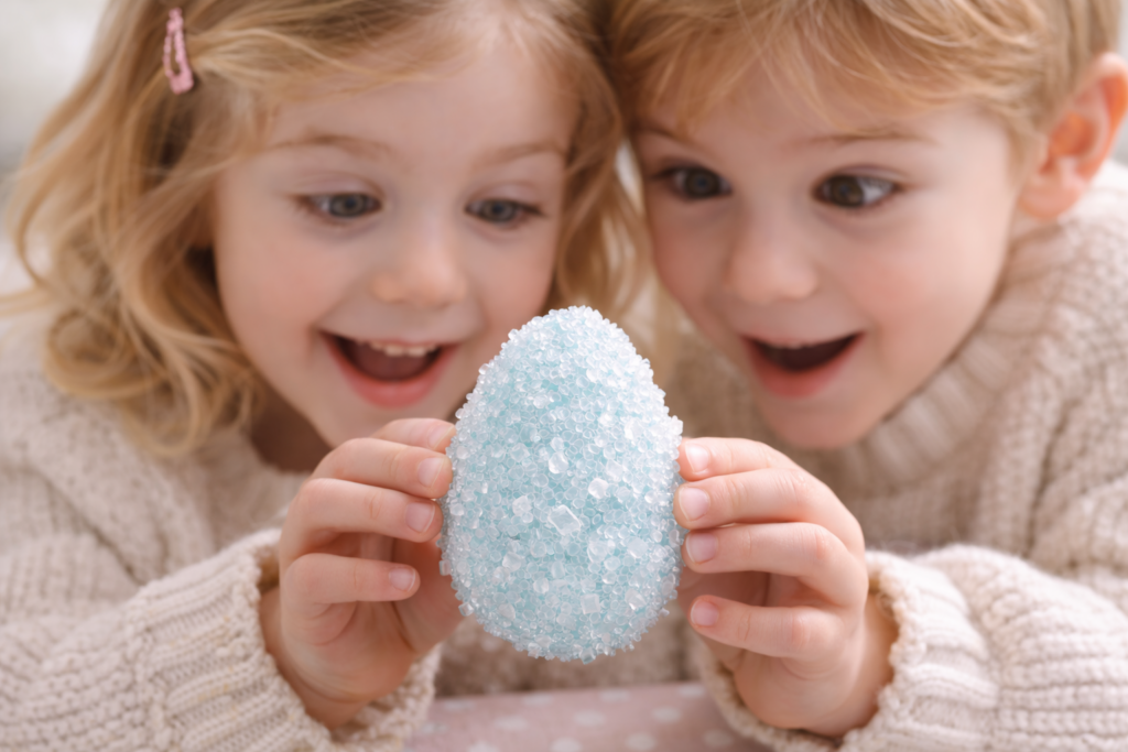 Kinder bewundern glitzerndes Osterei